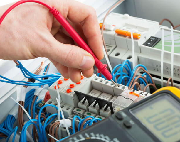 Sähkönmittaaminen Mies mittaa sähkövirtoja ja vastuksia.